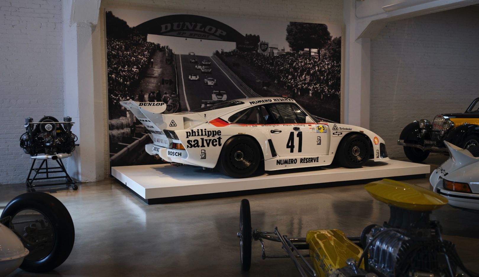 Au milieu de dragsters américains iconiques, siège une victorieuse du Mans : la Porsche Kremer 935 K3.