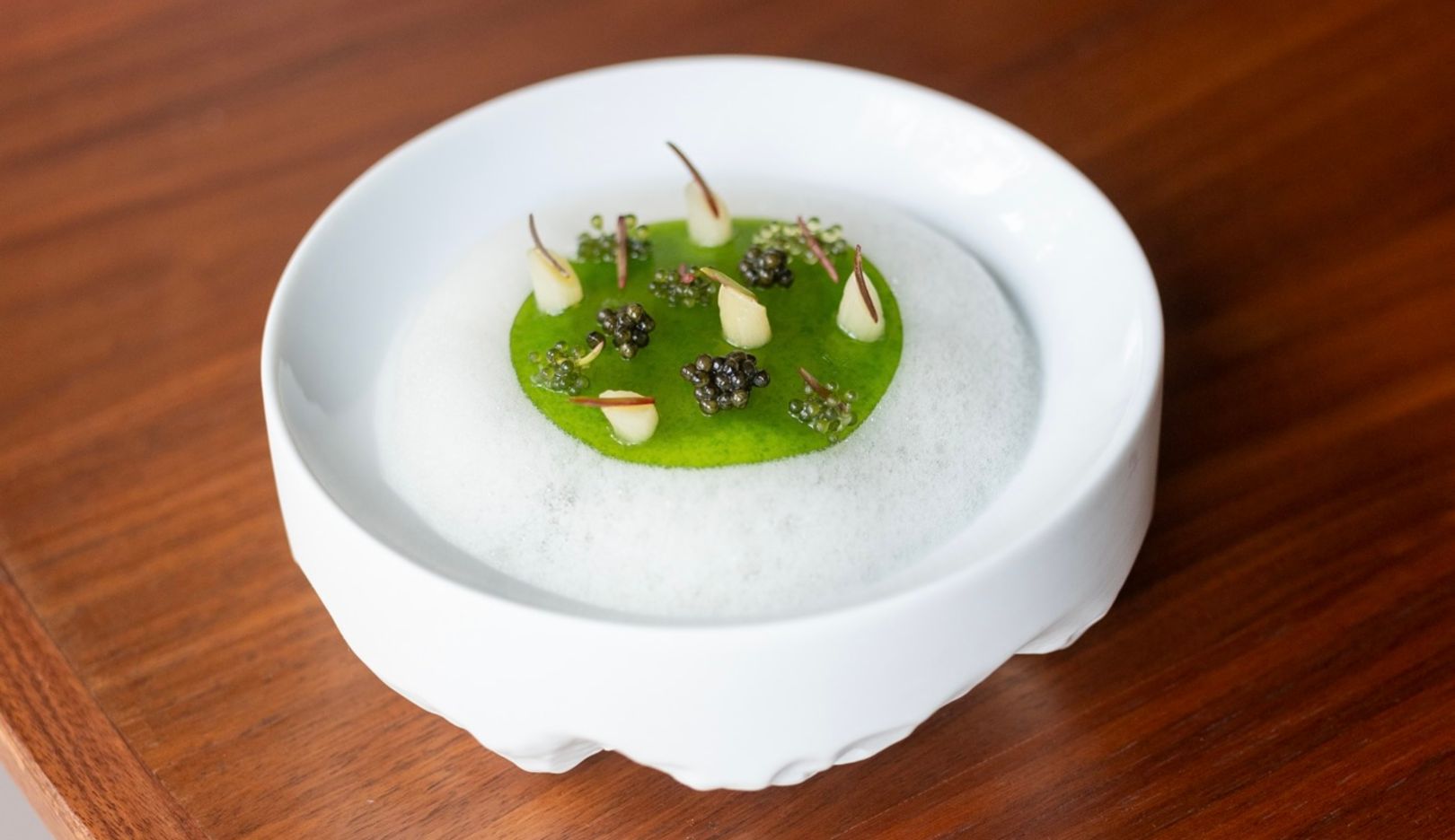 Création d’exception : sur la mousse blanche (confectionnée avec du daidai, un agrume) flotte une île de gelée d’algues garnie de caviar et de raisin bord de mer. Le tartare d’huitre se cache juste au-dessous.