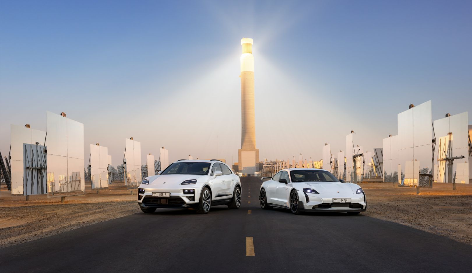 The Macan Turbo and Taycan Turbo GT with Weissach package in Dubai in front of the tallest solar tower in the world.