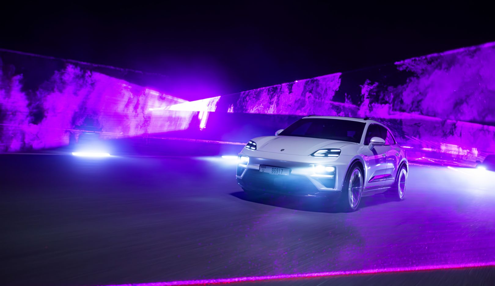 Through the laser backdrop, the Macan Turbo demonstrates its impressive performance capabilities.
