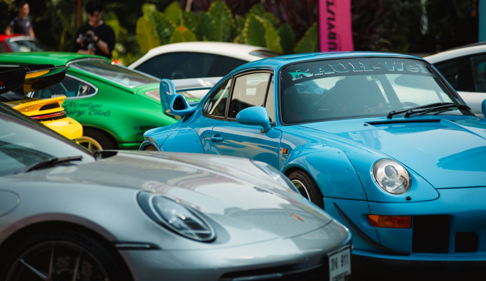 Colorful Curvistan: Porsche models of all different colors park in front of the pop-up store.