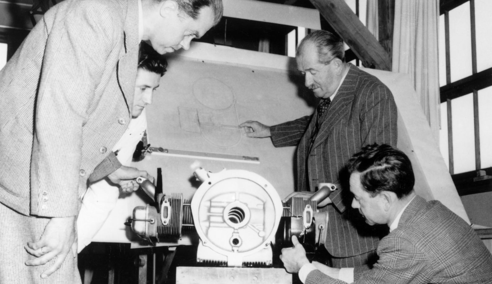 1950: Ferry Porsche (bottom right) with his father Ferdinand Porsche (hand on the drawing board) in the engineering office of Porsche in Stuttgart-Zuffenhausen. At the front, on the left, engine designer Leopold Jäntschke.
