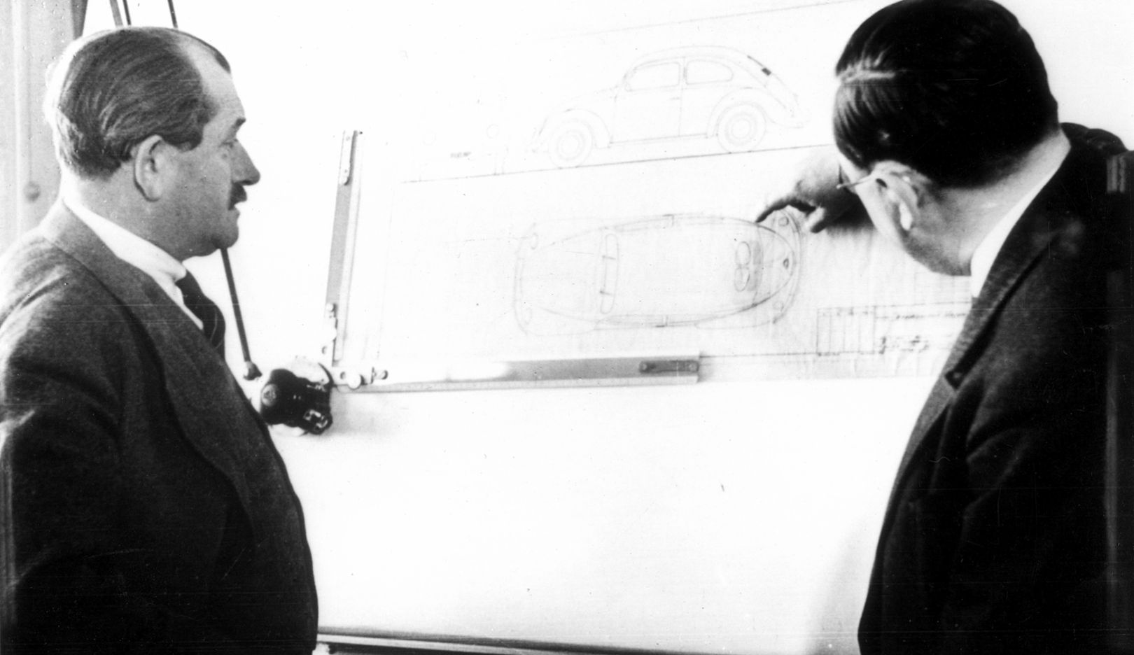 1938: Ferdinand Porsche (left) and Karl Rabe (right) at the drawing board, with a sketch of the VW 38 on it.