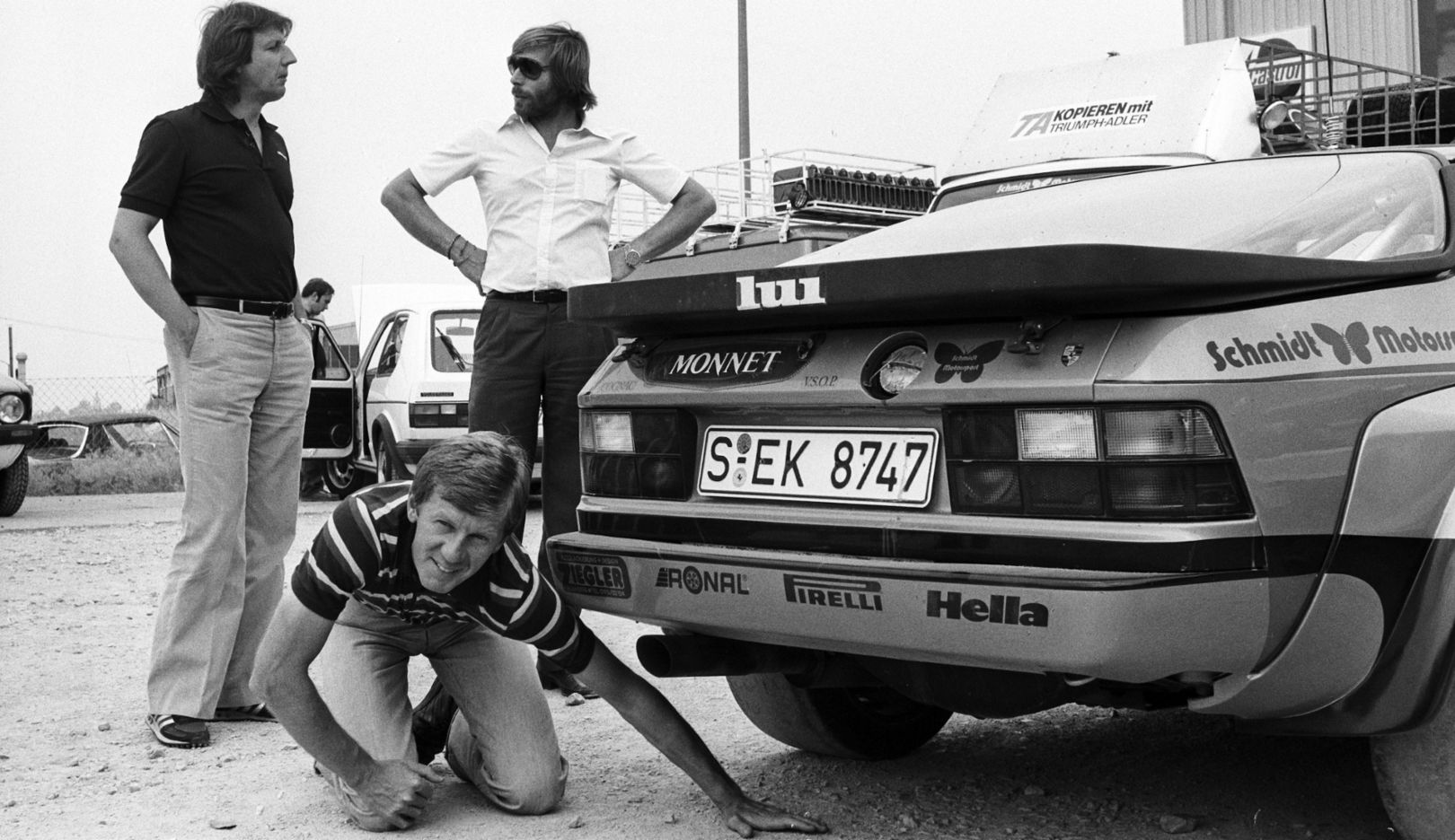 Alles in Ordnung? Walter Röhrl (Mitte) mit Porsche Rennfahrer Jürgen Barth beim Check des Porsche 924 Carrera GTS Rallye für den Rallyeeinsatz 1981.