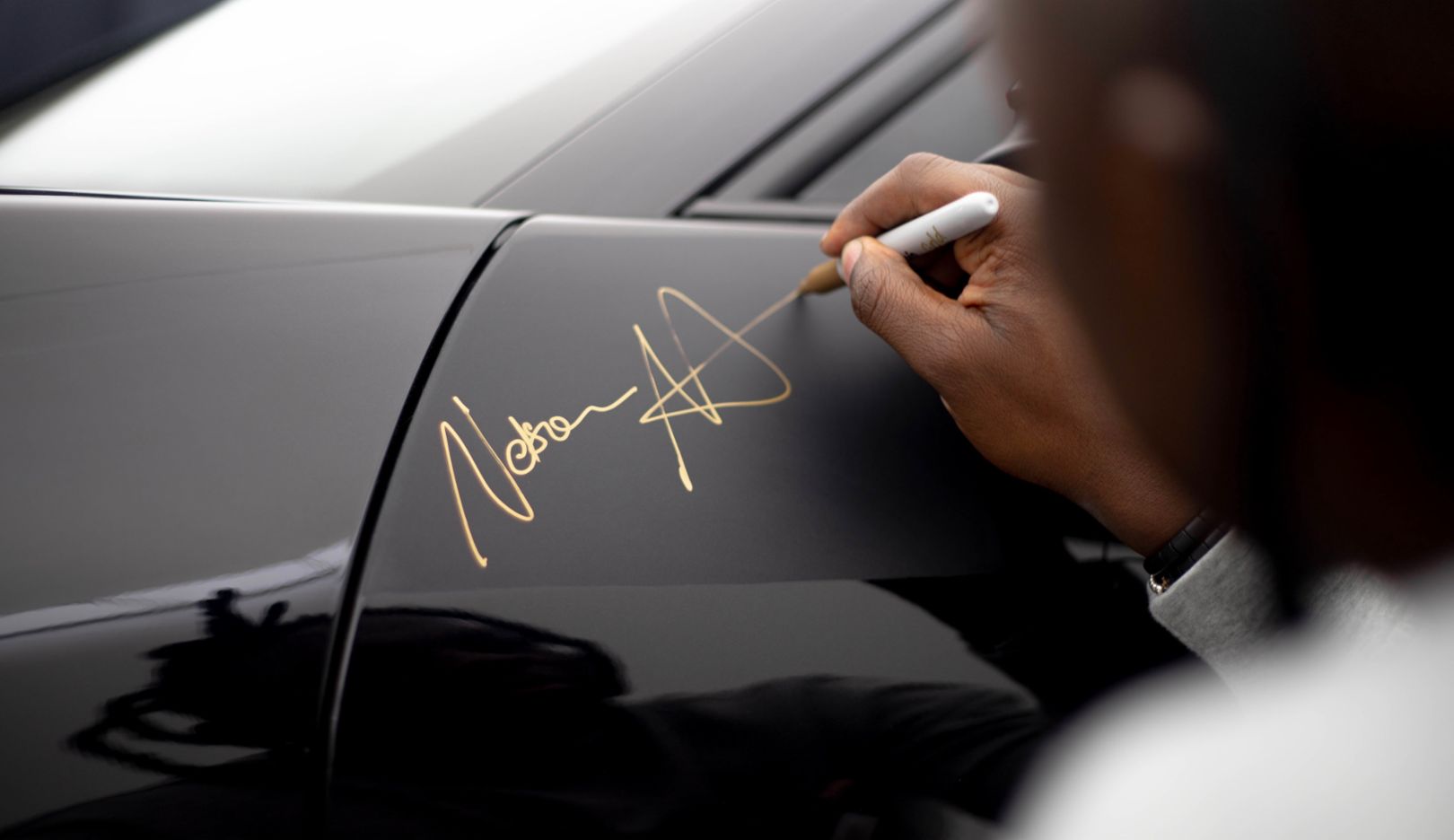 Signing a unique creation: The artist's final touch after his Porsche 911 is assembled.