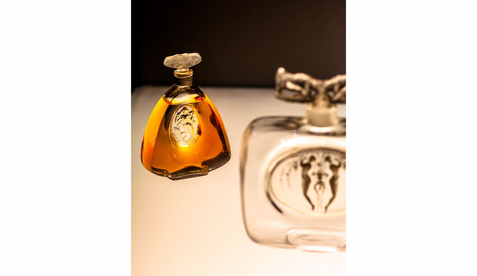 René Lalique created the motif of the bottle on the left as early as 1912, but it was not until 1934 that the mermaid became established. Here, La Sirène adorns a Brumann brand flacon. 