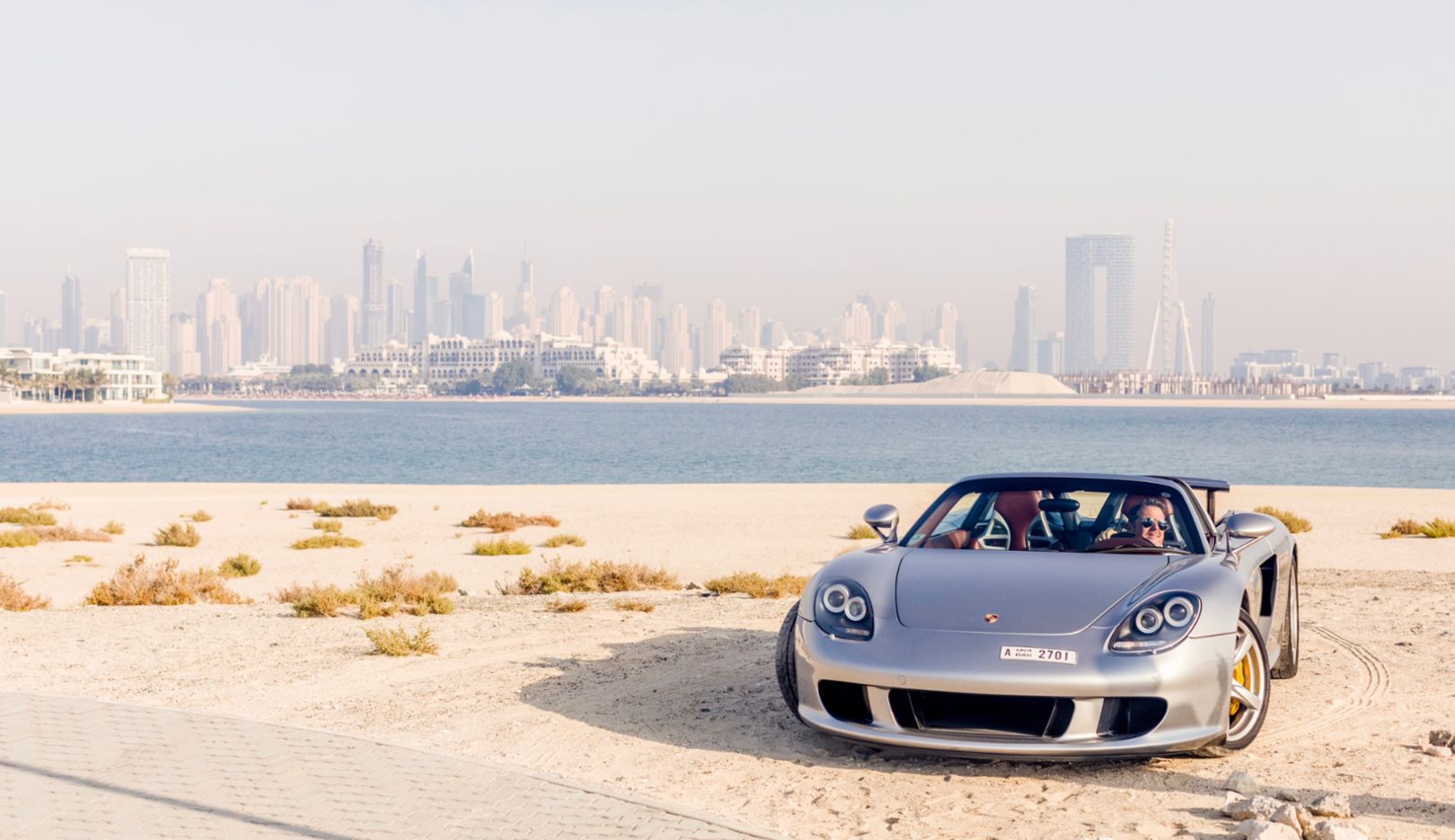 Mit dem Porsche Carrera GT besitzt Karim Al Azhari auch einen der seltenen Supersportwagen. Vor der Skyline Dubais macht die Rarität eine besonders gute Figur.