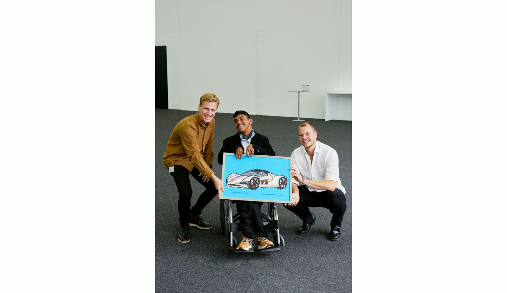 Design-Studio: Krithin consegna ai designer Stéphane Lenglin (a sinistra) e Tobias Benedini (a destra) un regalo davvero unico: il suo disegno della Porsche Vision Gran Turismo.