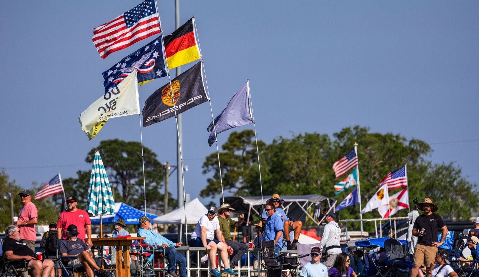 Fan camp: Spectators mark their spots right by the fence with flags.