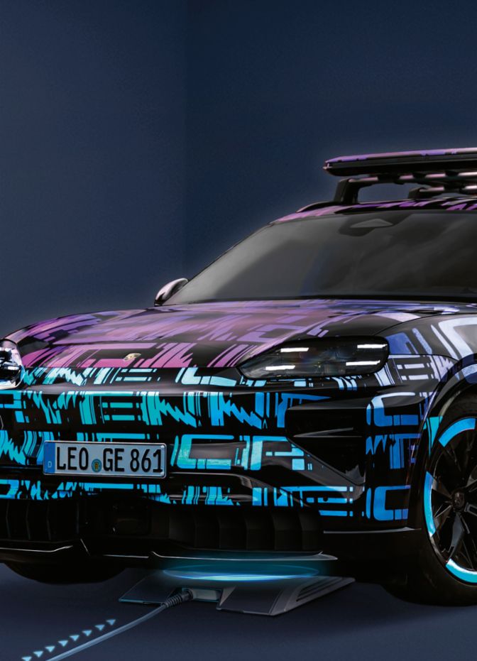Ein futuristisch gestaltetes Auto mit leuchtenden, abstrakten Mustern steht in einem dunklen Raum, während es an einer Ladestation angeschlossen ist.