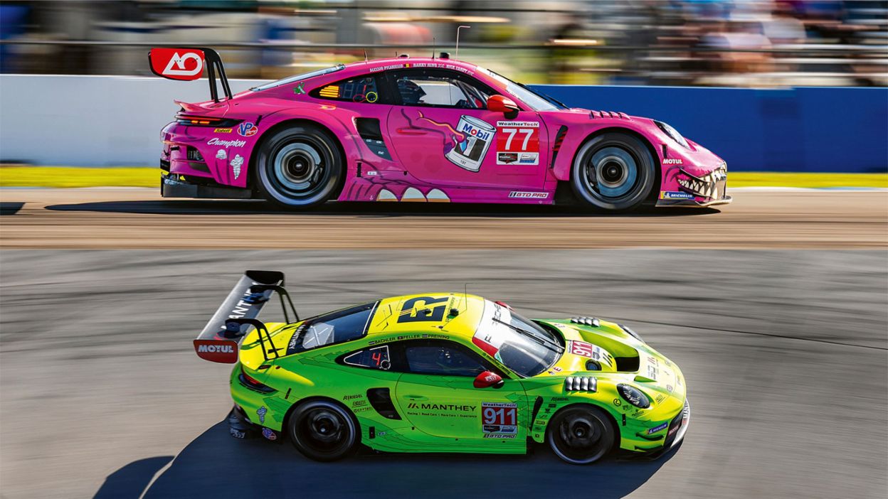 Two brightly colored race cars drive side by side on a racetrack.